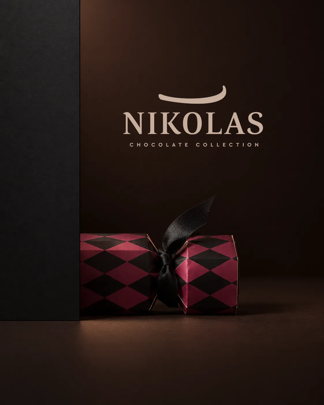 Estuche borgoña junto a la identidad original de Nikolas Chocolate Collection, sobre un fondo oscuro.